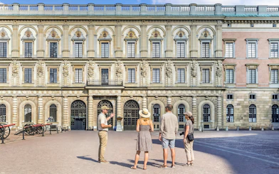 Tour group in front of historic royal palace facade in Stockholm, Sweden.