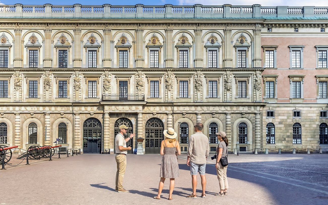 Tour group in front of historic royal palace facade in Stockholm, Sweden.