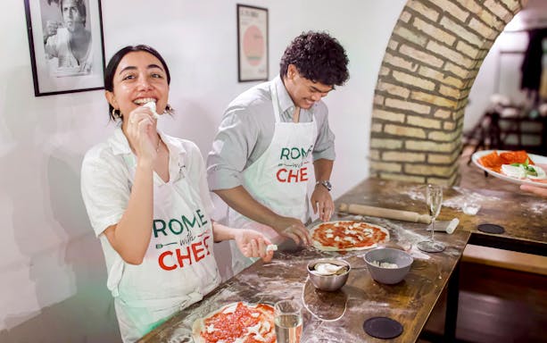 Participants making pizza in a Rome cooking class.