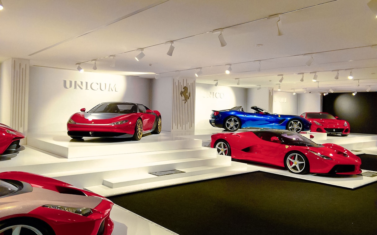 Luxury Ferrari cars on display in Maranello showroom.