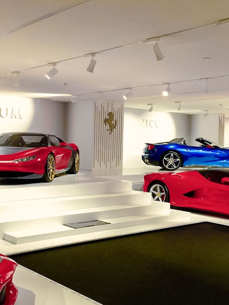 Luxury Ferrari cars on display in Maranello showroom.