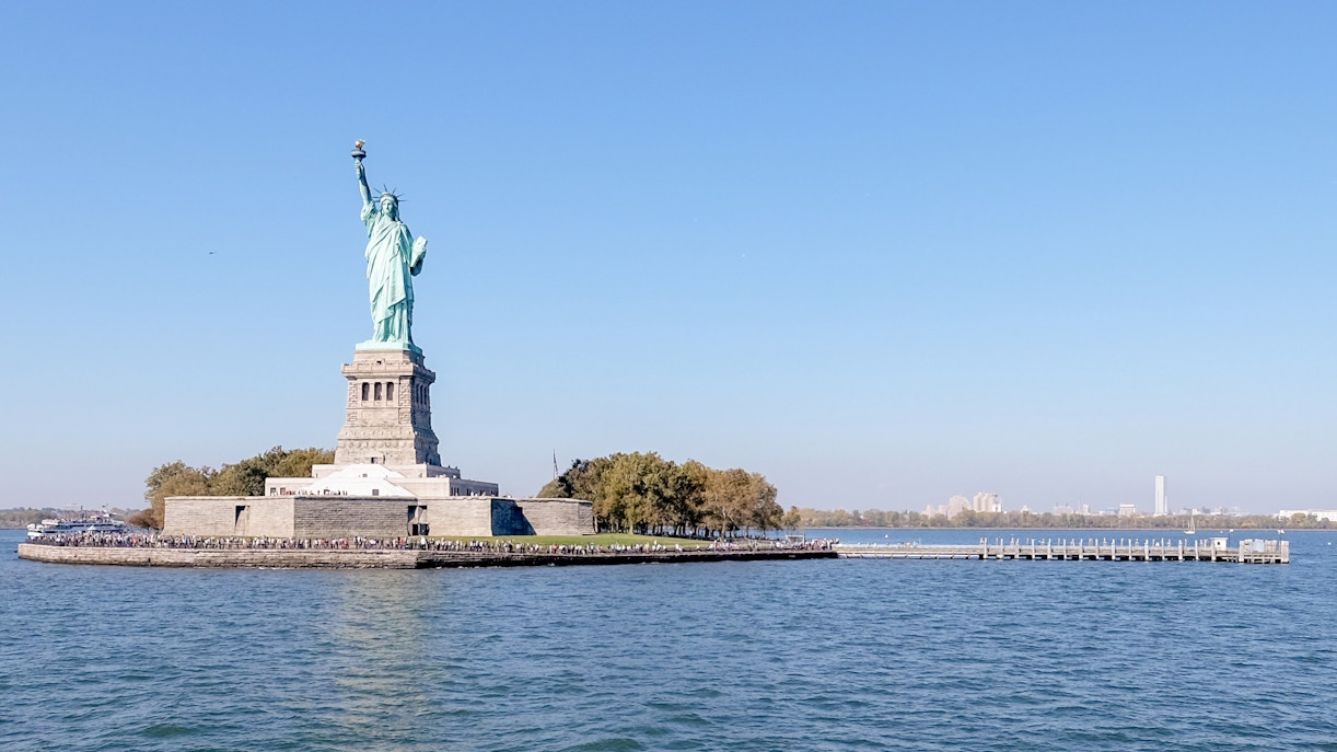 Statue of Liberty on Liberty Island, New York City, USA, with surrounding skyline.