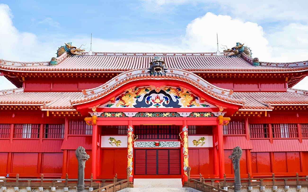 Shurijo Castle's vibrant red gate with ornate dragon carvings in Okinawa, Japan.