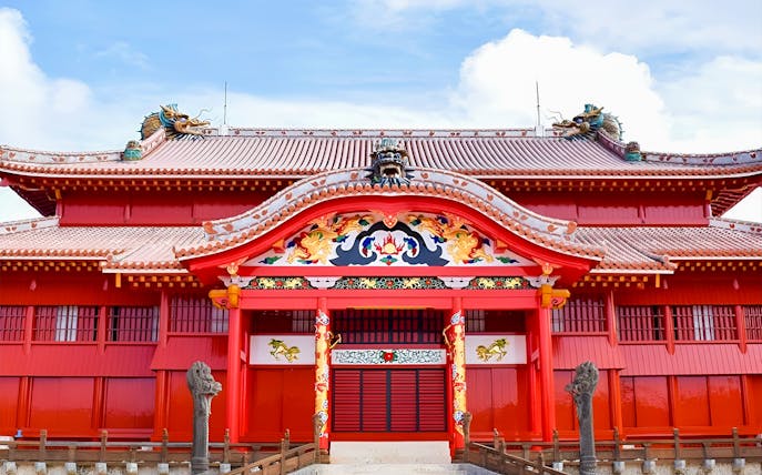 Shurijo Castle's vibrant red gate with ornate dragon carvings in Okinawa, Japan.