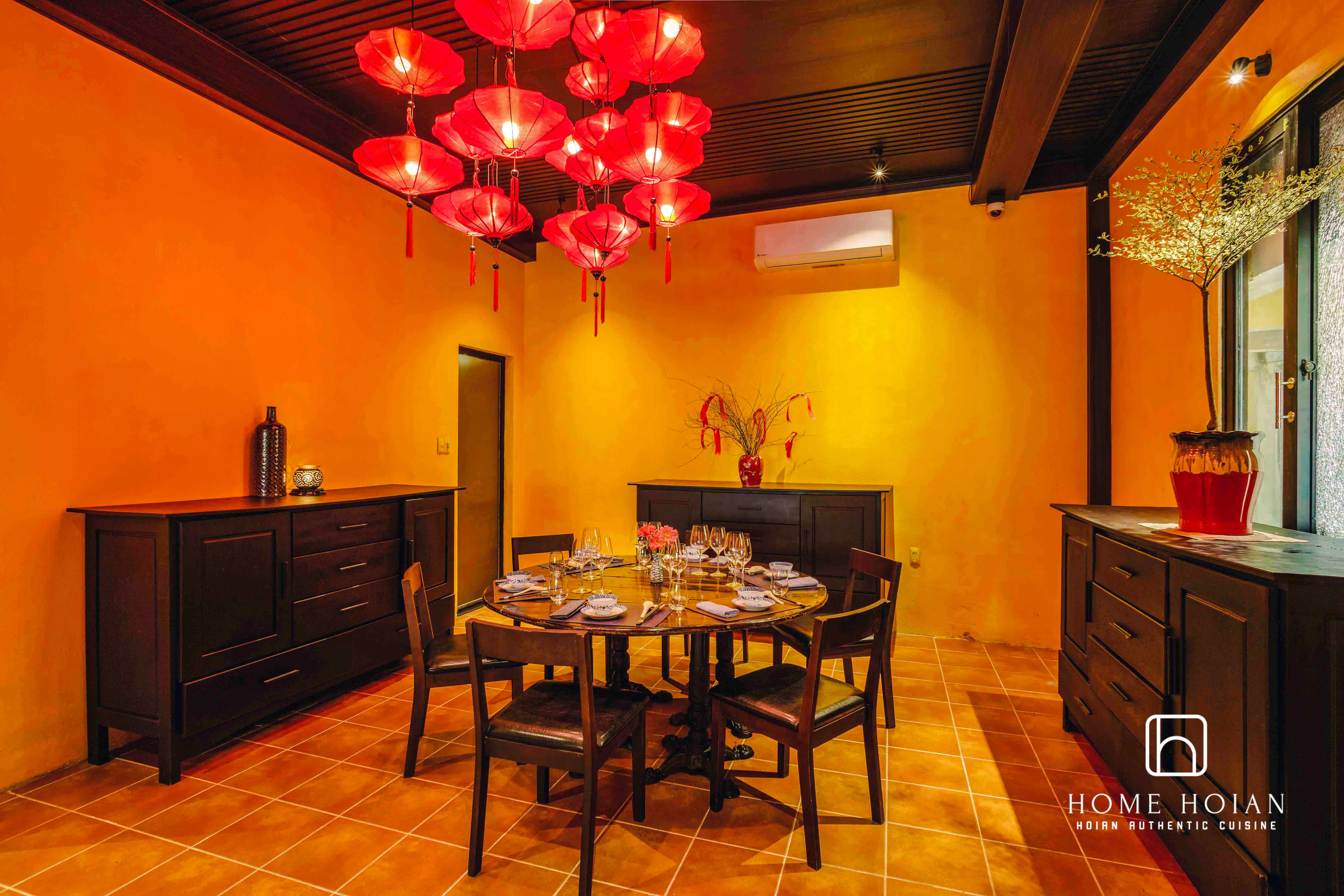 Dining room with round table set for guests at HOME Hoi An Restaurant, Hoi An.
