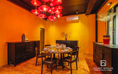 Dining room with round table set for guests at HOME Hoi An Restaurant, Hoi An.