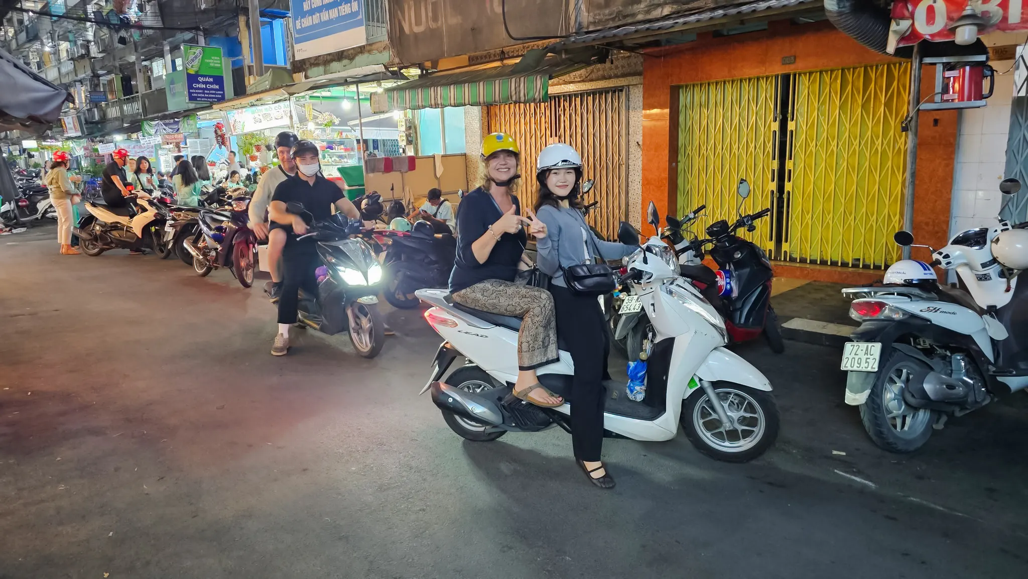 Motorbike riders on Saigon street food tour, Ho Chi Minh City, exploring local districts.