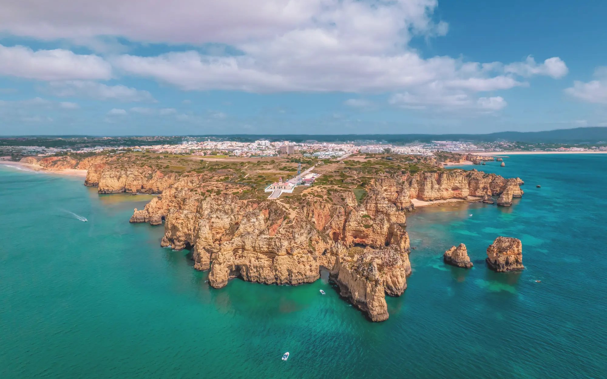 Aerial view of Algarve coastline near Benagil Caves, Portugal, with cliffs and turquoise sea.