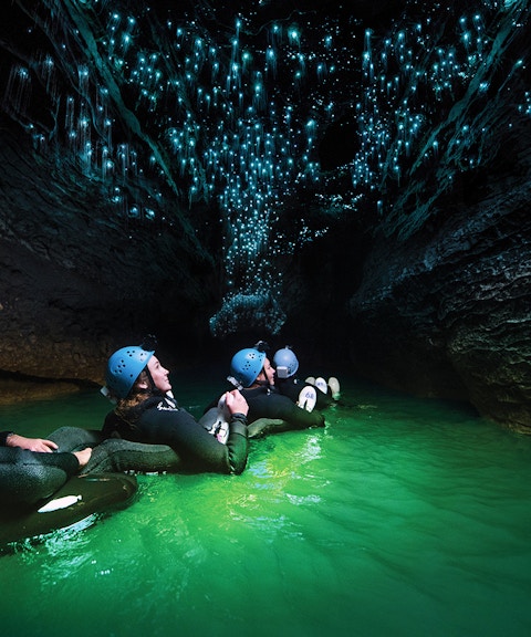 Guided black water rafting under glowworms in Waitomo Cave, New Zealand.