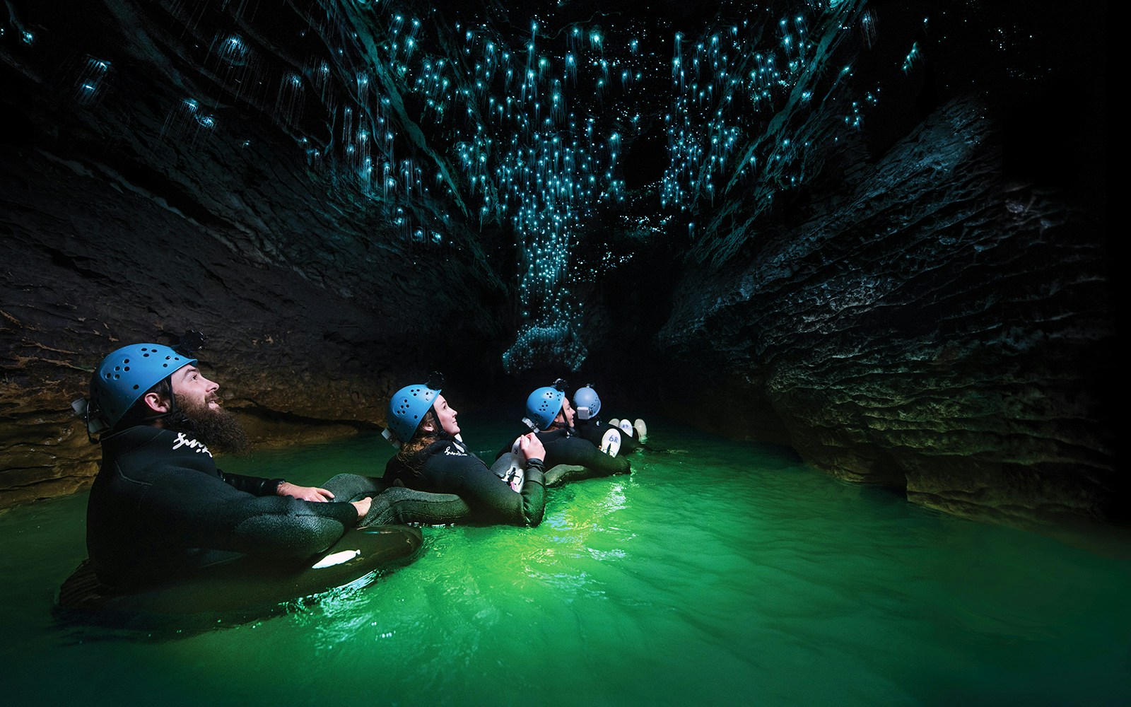 Guided black water rafting under glowworms in Waitomo Cave, New Zealand.