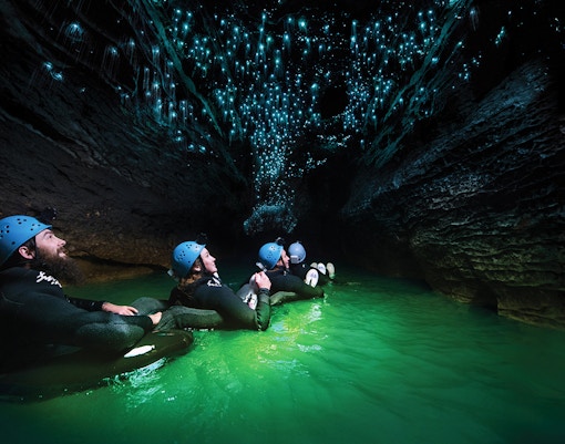 Guided black water rafting under glowworms in Waitomo Cave, New Zealand.