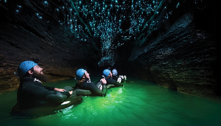 Guided black water rafting under glowworms in Waitomo Cave, New Zealand.