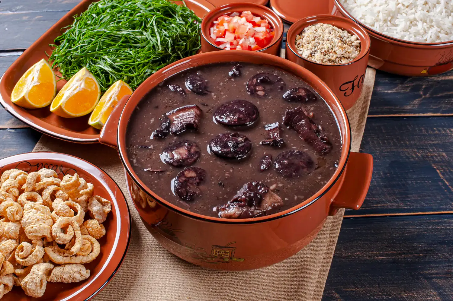 Feijoada with rice, greens, oranges, and farofa on Rio de Janeiro food tour.