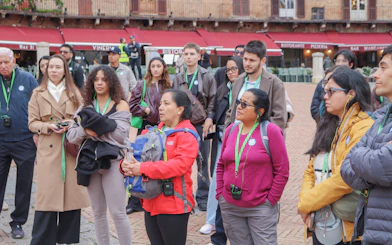 Tourists listening during a guided tour in an Italian piazza.