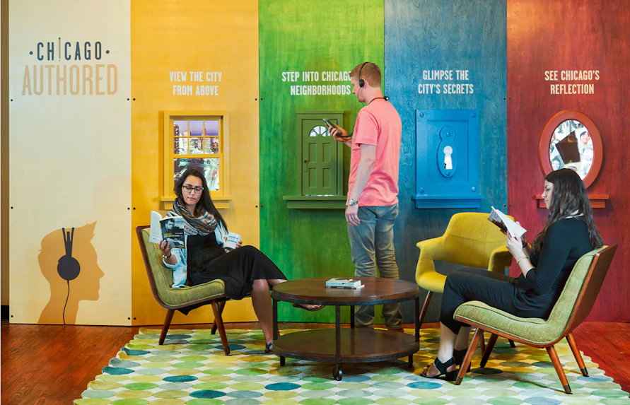Chicago exhibit with visitors engaging in interactive displays and reading, promoting city exploration.