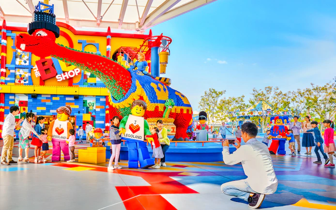 Visitors enjoying colorful Lego sculptures at Legoland Japan.