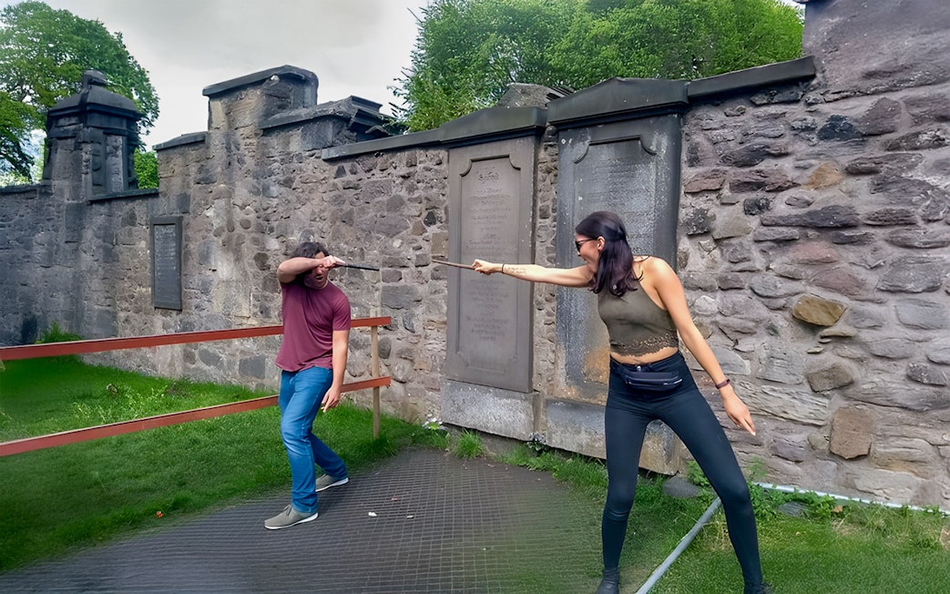 Two people reenacting a wand duel on the Harry Potter walking tour in Edinburgh.