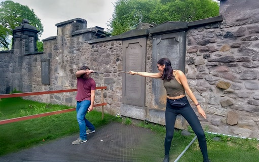 Two people reenacting a wand duel on the Harry Potter walking tour in Edinburgh.