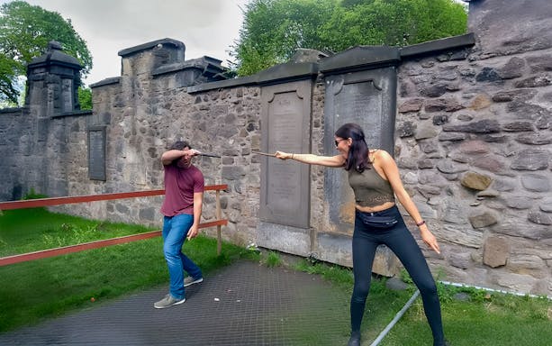 Two people reenacting a wand duel on the Harry Potter walking tour in Edinburgh.