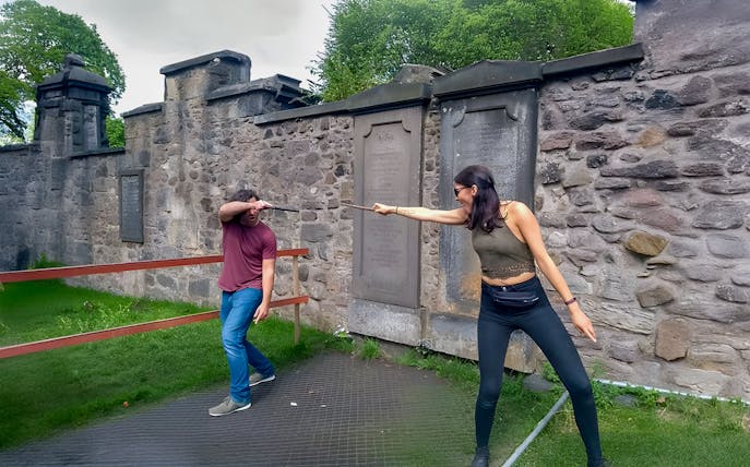 Two people reenacting a wand duel on the Harry Potter walking tour in Edinburgh.