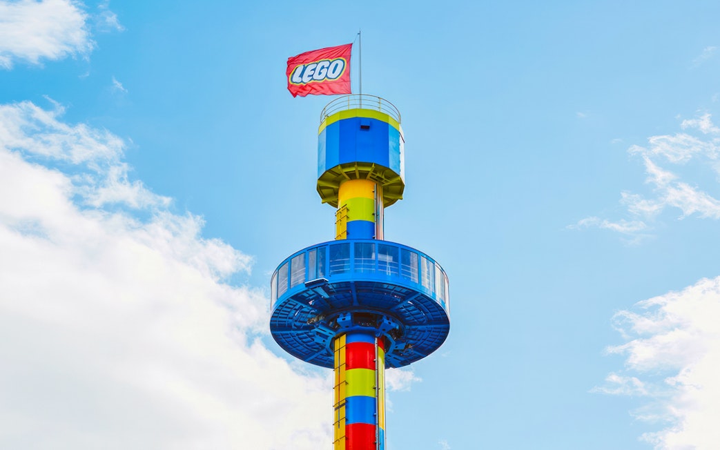 Observation tower with LEGO flag at Legoland Japan against blue sky.