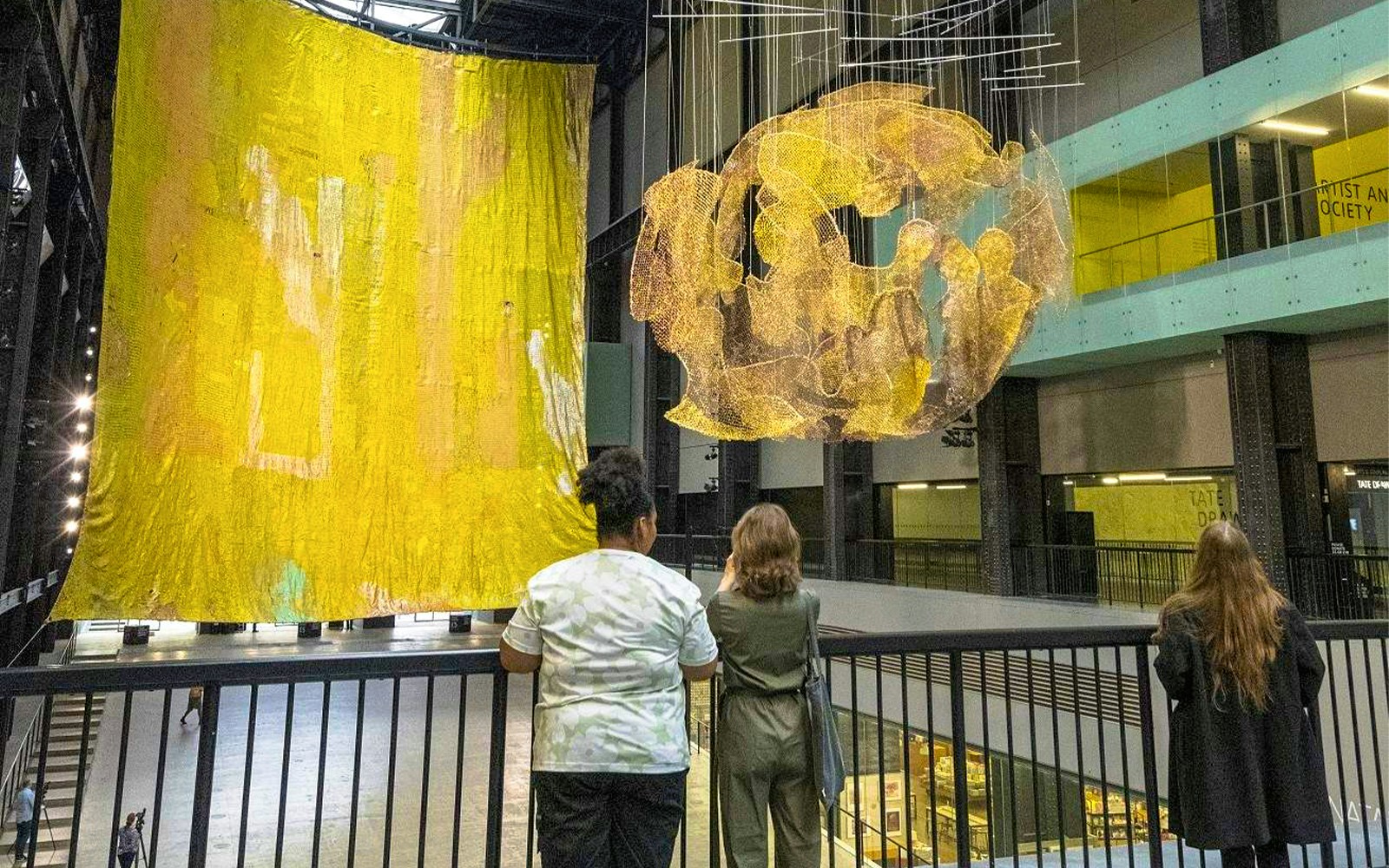 Visitors observing large art installations at Tate Modern, London.