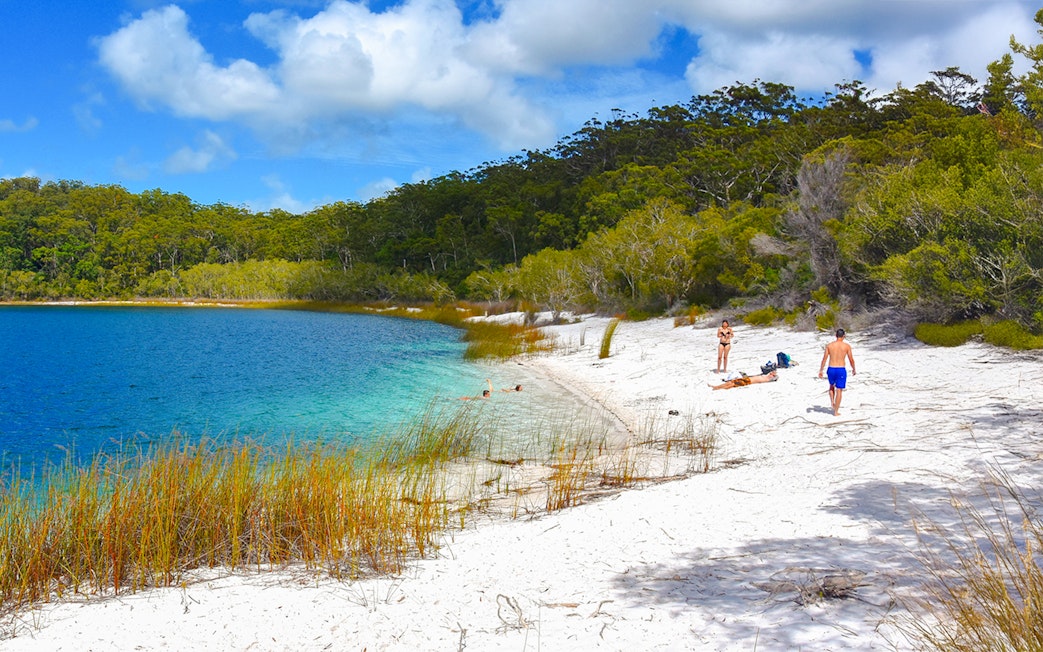 Visitors enjoying the white sandy beach and clear waters of Lake McKenzie, Fraser Island, K'gari.