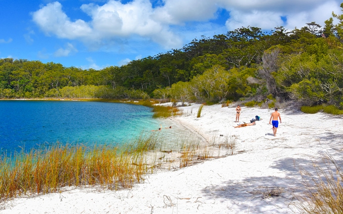 Visitors enjoying the white sandy beach and clear waters of Lake McKenzie, Fraser Island, K'gari.