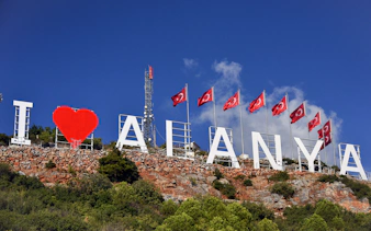 Alanya hillside sign with Turkish flags, part of Jeep and cable car day-trip.