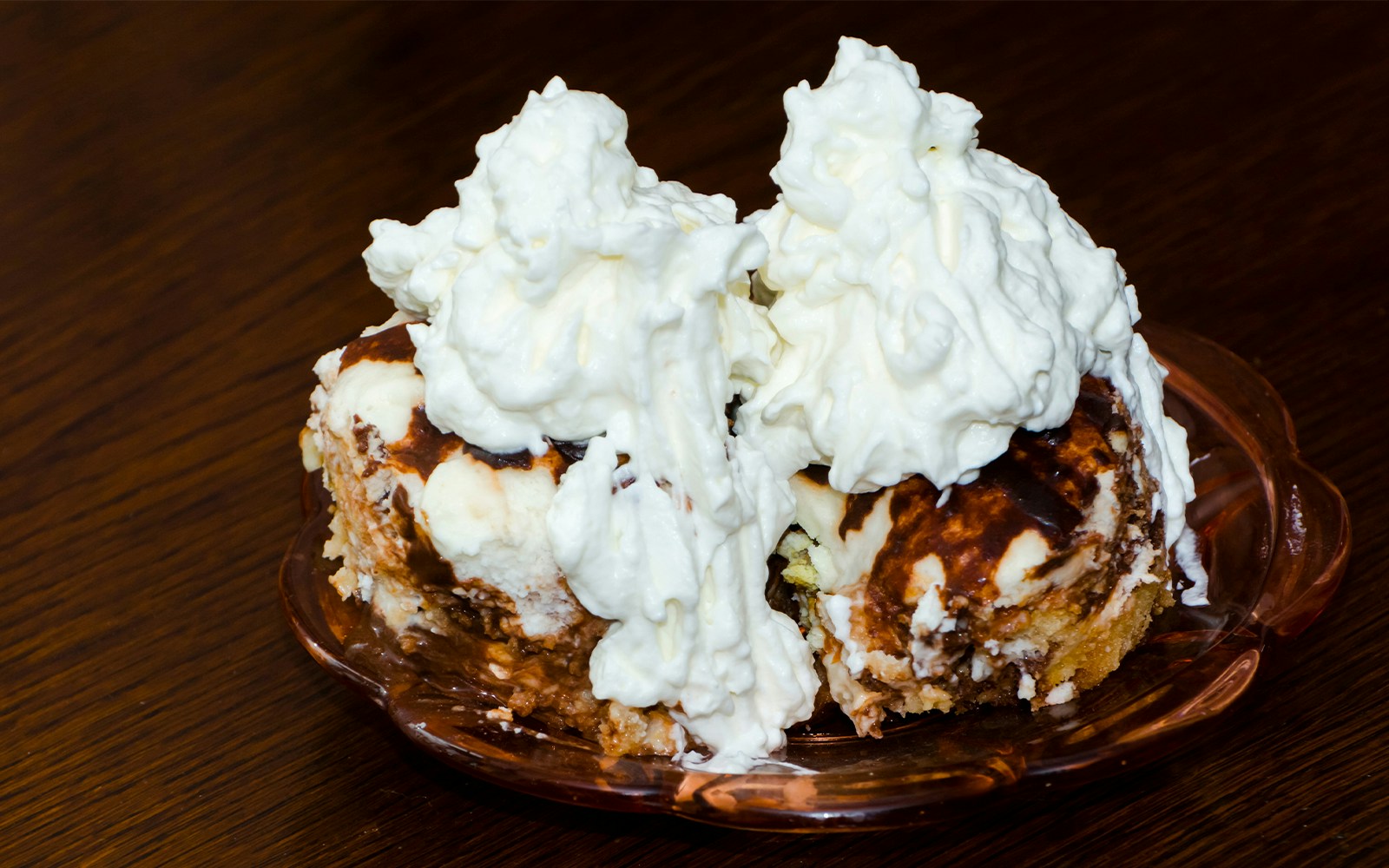 Hungarian sponge cake topped with whipped cream on a glass plate.