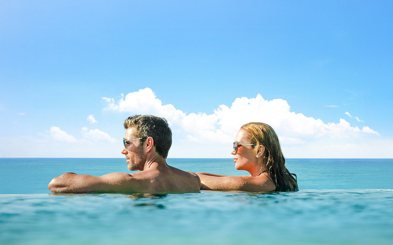 Guests enjoying an infinity pool with a view of the Dubai skyline.