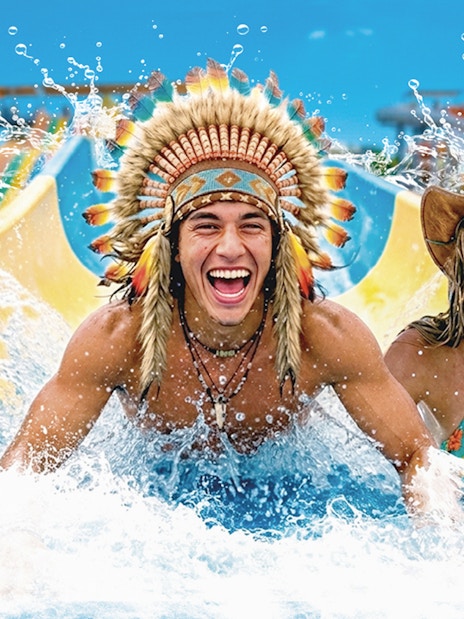 Tourists enjoying a water slide at Western Water Park.