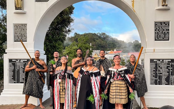 Villagers in traditional attire performing in front of Memorial Archway.
