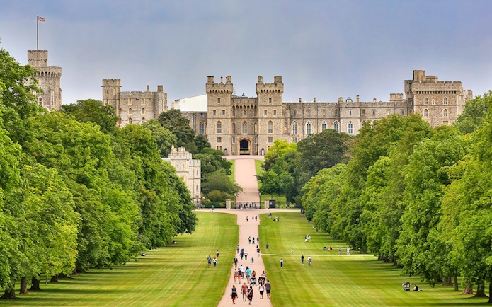 Windsor Castle view with visitors walking along the Long Walk, England.