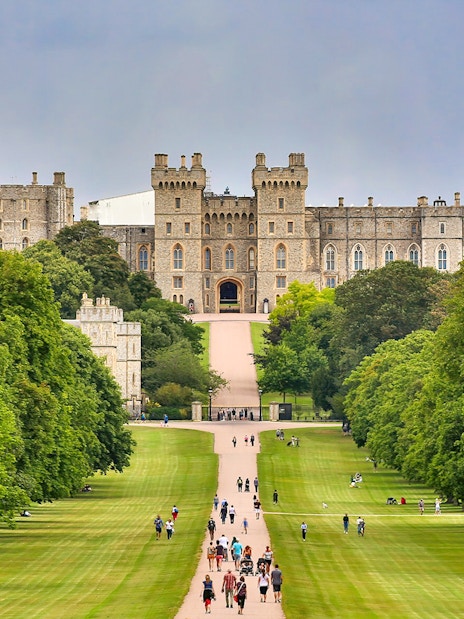 Windsor Castle view with visitors walking along the Long Walk, England.