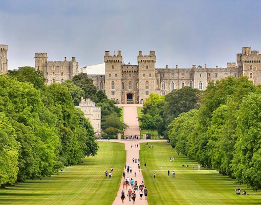 Windsor Castle view with visitors walking along the Long Walk, England.