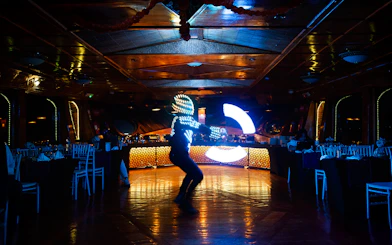 Performer in LED suit dancing on Dubai Marina luxury dhow cruise.