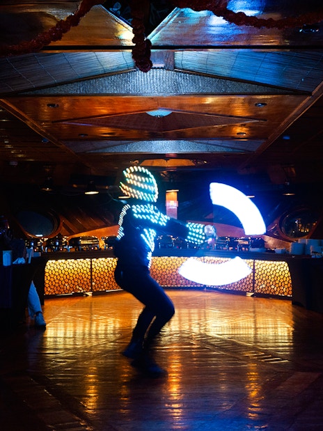 Performer in LED suit dancing on Dubai Marina luxury dhow cruise.