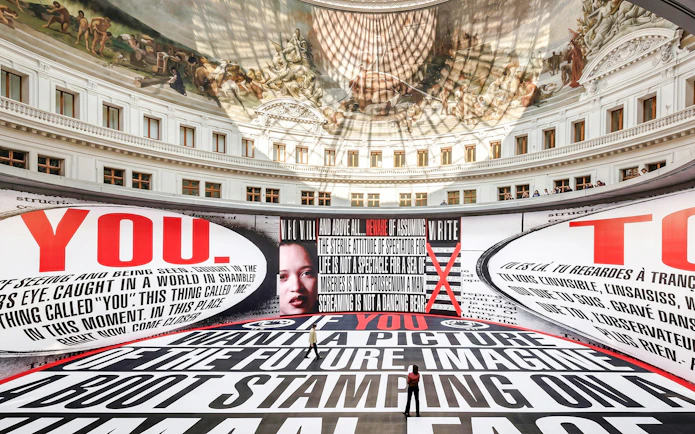 Bourse de Commerce Pinault Collection interior with large text installation and ornate ceiling fresco.