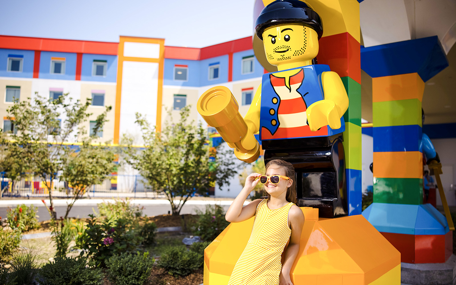 Child posing with large Lego figure at Legoland New York.
