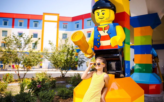Child posing with large Lego figure at Legoland New York.