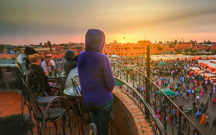 Woman overlooking Jema el Fna square in Marrakesh at sunset.