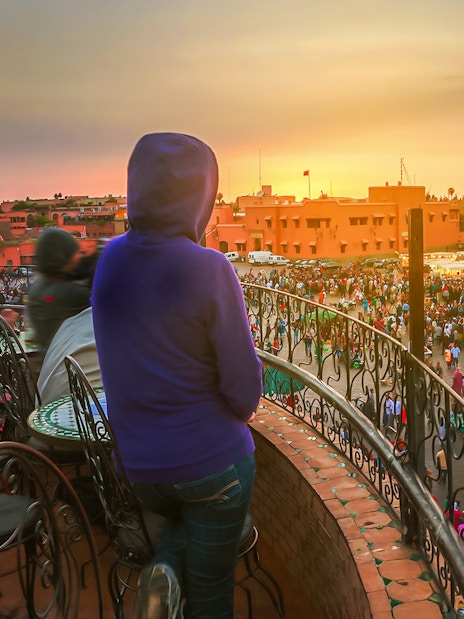 Woman overlooking Jema el Fna square in Marrakesh at sunset.