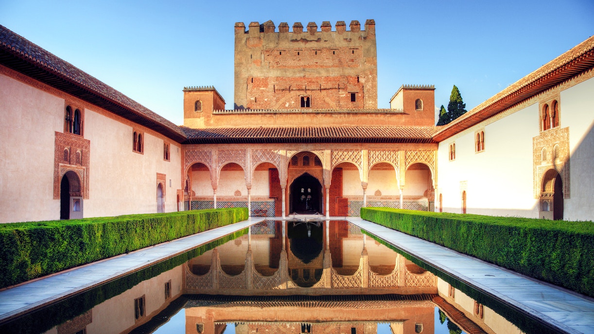 Inside view of Alhambra Palace, showcasing intricate Moorish architecture and detailed carvings in Granada, Spain.