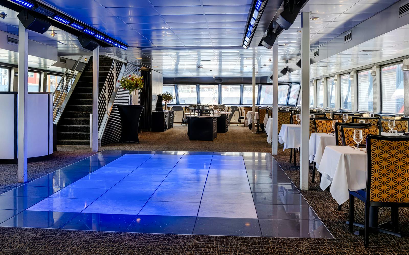 Interior of New Jersey Signature Cruise ship with dining tables and dance floor.