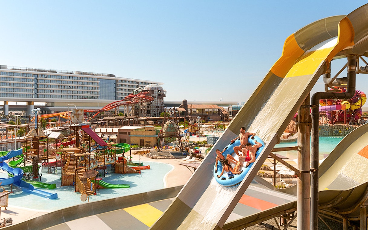 Visitors on a raft sliding down a water ride at Meryal Waterpark.