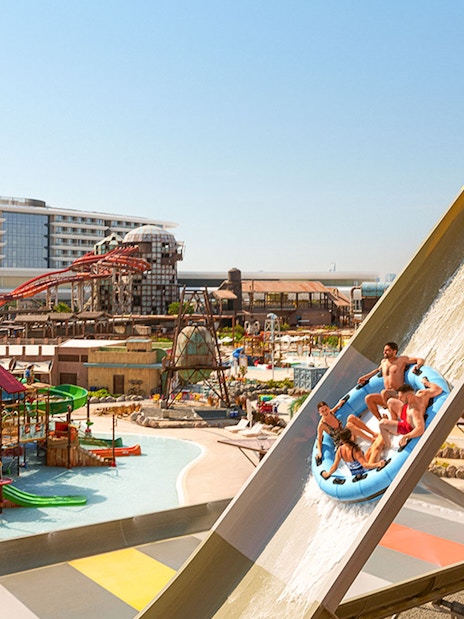 Visitors on a raft sliding down a water ride at Meryal Waterpark.