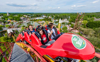 Roller coaster ride at Parc Asterix with scenic park view in the background.