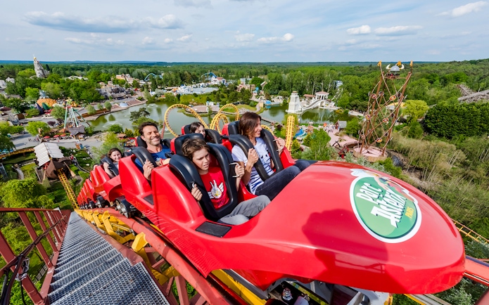 Roller coaster ride at Parc Asterix with scenic park view in the background.