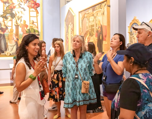 Tour group with guide at Accademia Gallery, Florence, viewing Michelangelo's David statue.